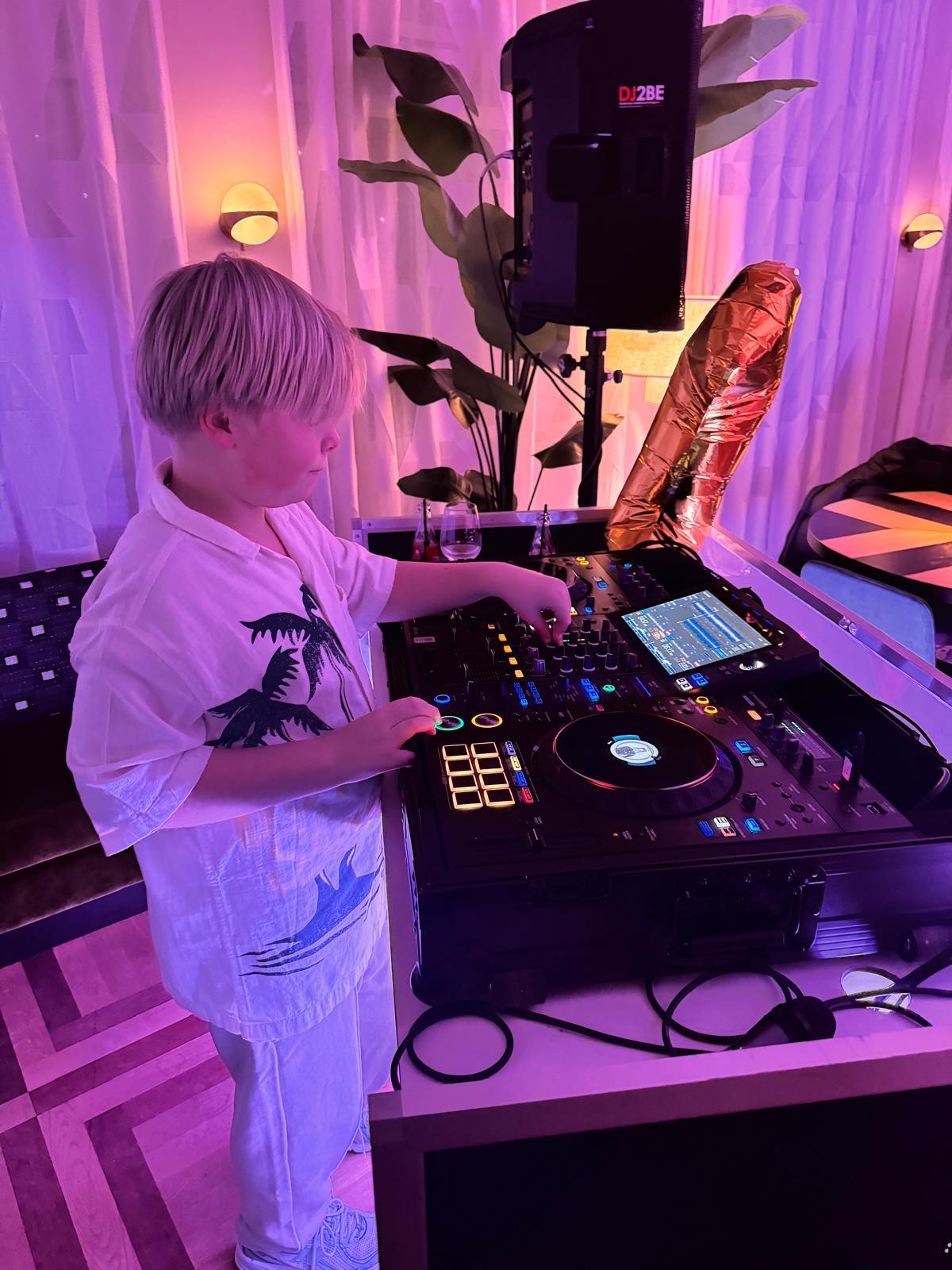 DJDura Hugo mixing music on a DJ controller under colorful party lights